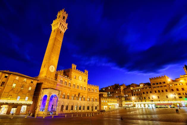 photo of piazza del campo in the historic center of siena, Tuscany, Italy, with palazzo pubblico and torre del mangia tower at late evening.