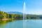 Photo of grand park in Tirana viewed behind a fountain on an artificial lake, Albania.