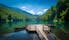 Photo of panoramic view of Biogradsko lake. Virgin forests and beautiful mountains, wooden pier and boats.