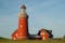 Photo of beautiful red Lighthouse Bovbjerg Fyr with green grass and blue sky, Danish North Sea coast, Jutland, Denmark.