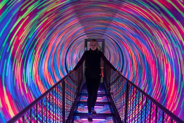 Camera Obscura World of Illusions amazing exhibition of cool light effects and shows. Model standing in cool colorful tunnel.
