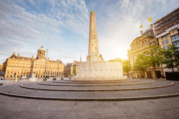 Photo of morning view on the Dam square with Royal palace and monument in Amsterdam city during the sunny weather.