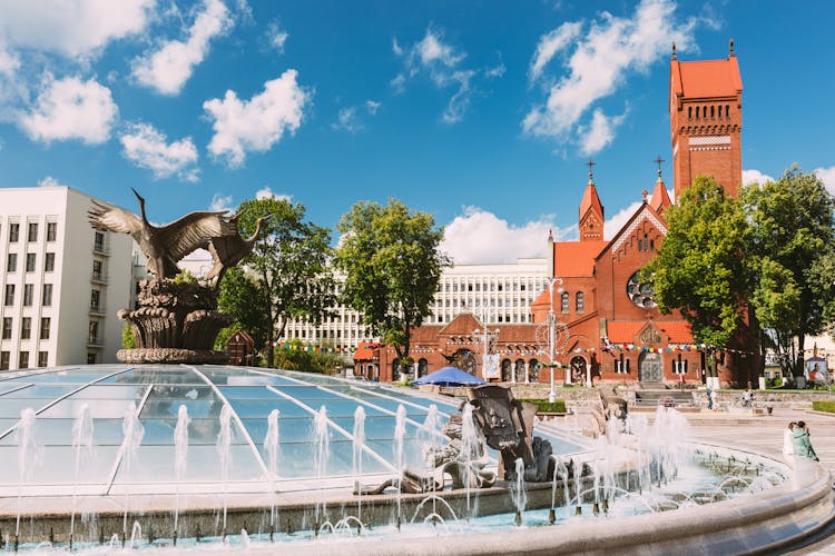 Photo of church Of Saints Simon And Helen or Red Church And Fountain At Independence Square In Minsk.