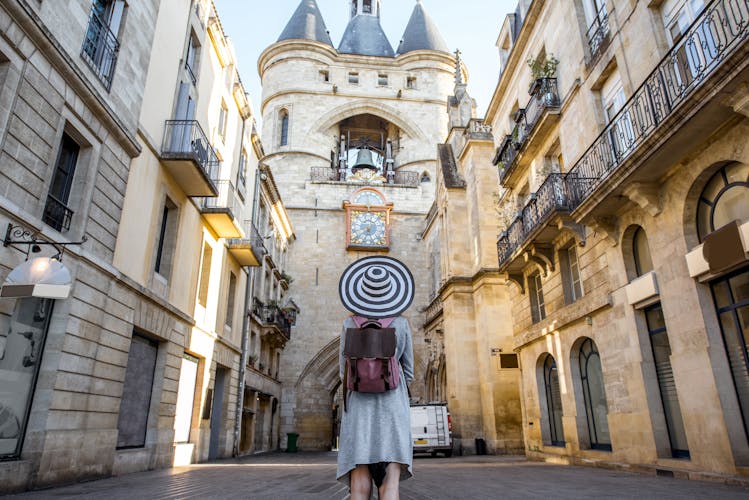 Photo of tourist standing back in front of the famous bell tower in Bordeaux city in France.