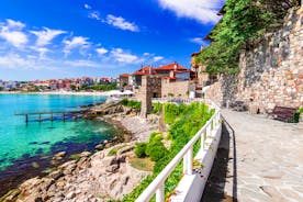 Photo of Saint Anastasia Island in Burgas bay, Black Sea, Bulgaria. Lighthouse tower and old wooden buildings on rocky coast.