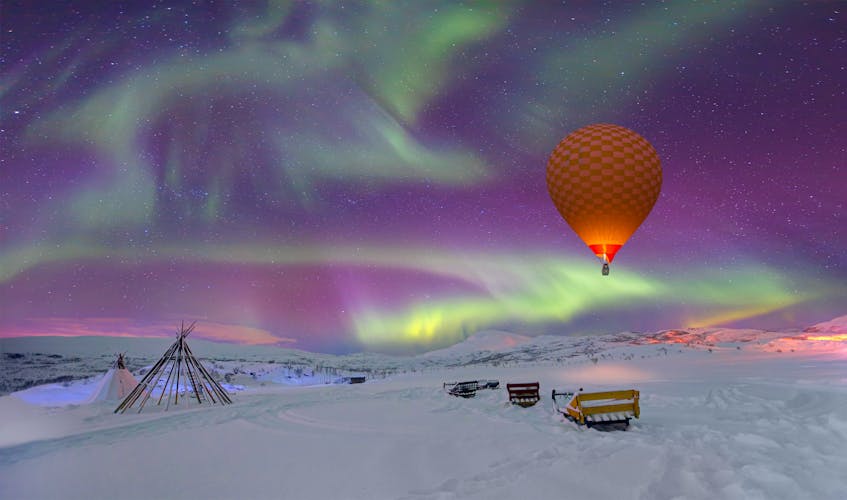 Photo of Northern lights in the sky and triangle cloth tent with hot air balloon - Tromso, Norway
