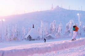 Photo of stunning sunset view over wooden huts and snow covered trees in Kuusamo, Finnish Lapland.