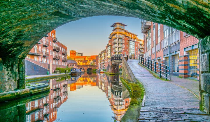 Photo of sunset view of brick buildings alongside a water channel in the central Birmingham, England.