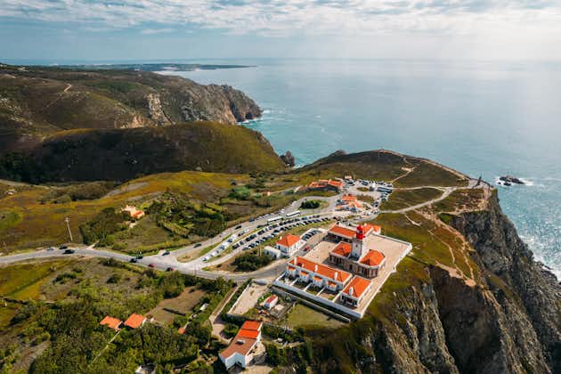 Photo of aerial drone view of lighthouse at Cabo da Roca with unidentifiable tourists enjoying the amazing views.