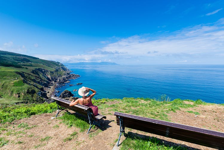 Photo of woman sitting on a bench in the Ribera near Estaca de Bares, La Coruña, Galicia, Spain.