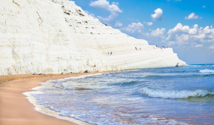 Photo of sandy beach under famed white cliff, called "Scala dei Turchi", in Sicily, near Agrigento, Italy.