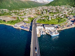 Photo of houses, bridge and panorama of Norwegian city Tromso beyond the Arctic circle from mountain in Norwegian fjords.