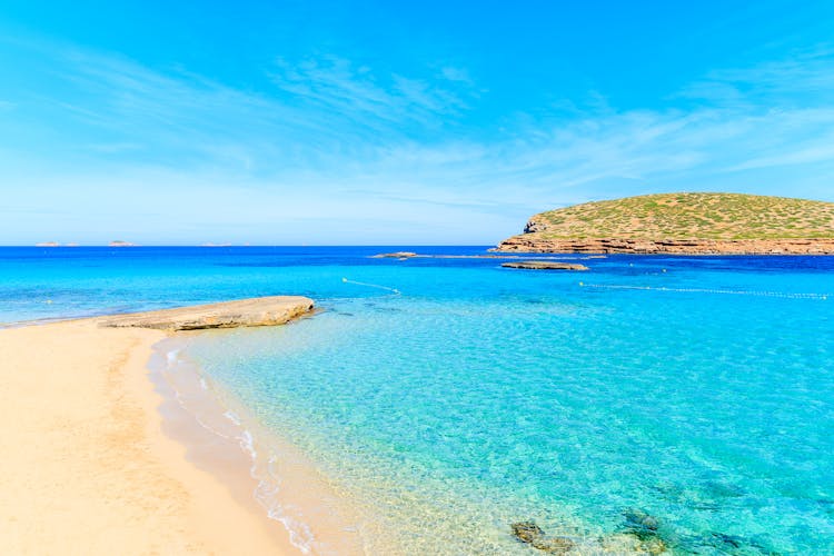 Photo of beautiful sandy Cala Comte beach with azure blue sea water, Ibiza island, Spain.
