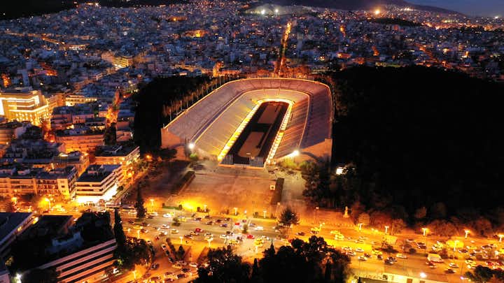 Photo of aerial drone night shot of illuminated beautiful ancient stadium of Kalimarmaro or Panathenaic where first classic Olympic games were held at dusk with beautiful colours, Athens, Attica, Greece.