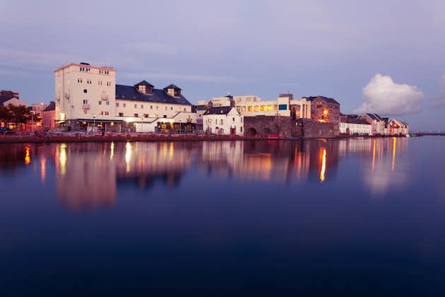 photo of Buildings on the bank of the river during High tide in the city in dusk. Claddach, Galway, Ireland.