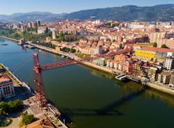 Photo of aerial view of Vizcaya bridge over the river and cityscape at Portugalete, Spain.