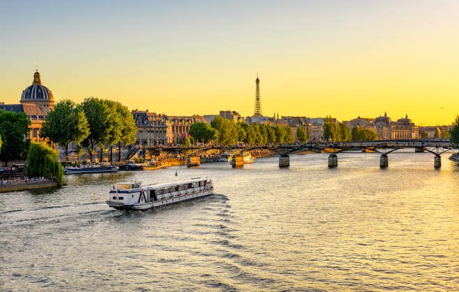 photo of a beautiful sunset view of Eiffel tower, Pont des Arts and Seine River in Paris, France.