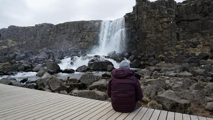 photo of young girl looking at Öxarárfoss waterfall in Iceland.
