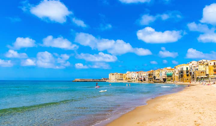 Photo of sandy lovely beach with beautful blue sky in Cefalu town, Sicily island, Italy. 