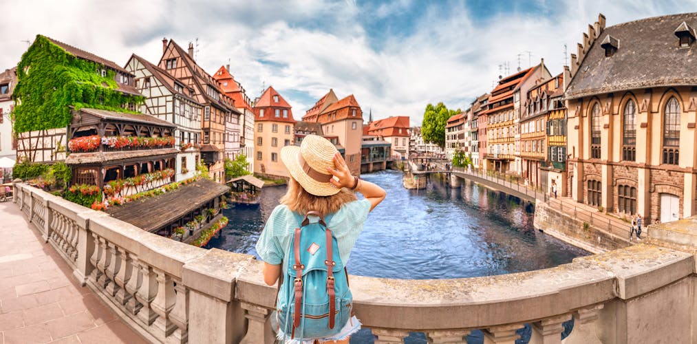 Photo of girl standing on a bridge over d Ill river in Strasbourg, France.