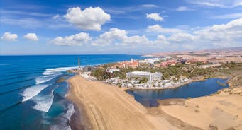 photo of landscape with Maspalomas town and golden sand dunes at sunrise, Gran Canaria, Canary Islands, Spain.