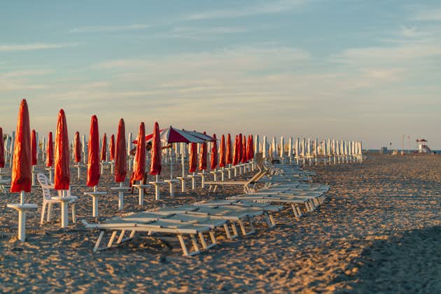 Photo of the sunbeds at sunset on the beach of the Adriatic Sea in Lido di Spina, Italy.