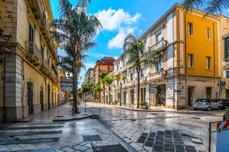 Empty streets and closed shops and cafes on a summer morning on the main street, Corso Umberto, through the town center of the coastal city of Brindisi, Italy.