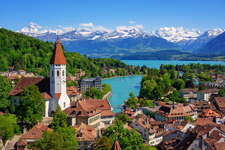 Photo of Historical Thun city with snow covered Bernese Highlands swiss Alps mountains in background, Bern, Switzerland.