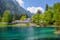 photo of Springtime at Romantic Forest Lake Blausee. One of the best-known mountain lakes in Switzerland. Beautiful crystal-clear color water with green tree around the lake.