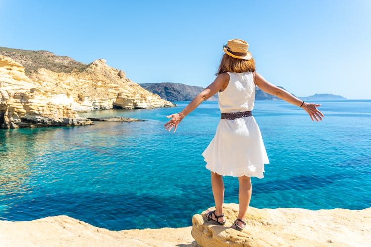 Photo of tourist woman looking at the sea in Rodalquilar in Cabo de Gata on a beautiful summer day, Almería.
