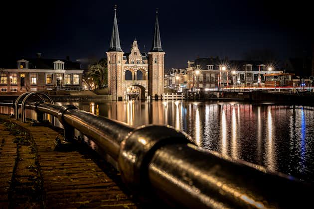 photo of the Waterpoort in Sneek surrounded by buildings and the river during the night in Sneek in the Netherlands.