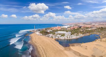 photo of landscape with Maspalomas town and golden sand dunes at sunrise, Gran Canaria, Canary Islands, Spain.