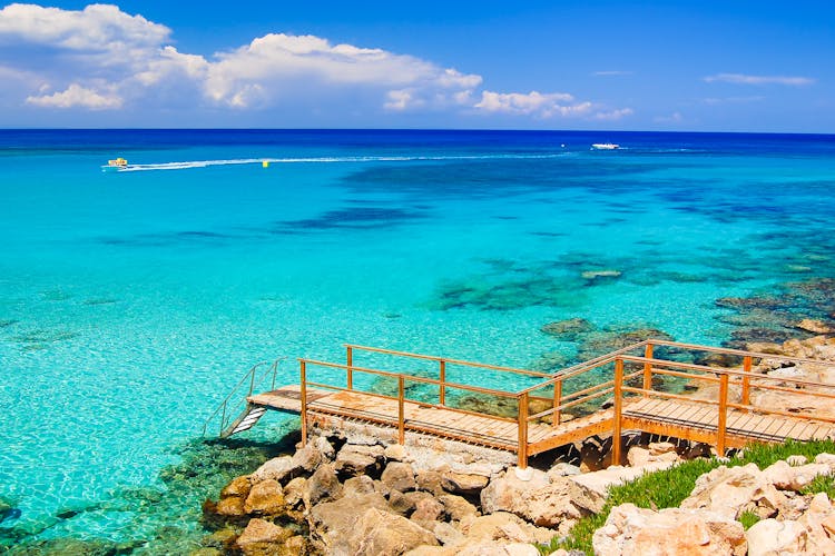 Photo of wooden platform with steps to azure sea water near Protaras, Cyprus island.
