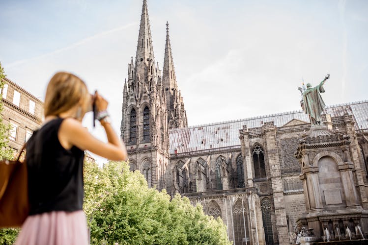 Photo of woman enjoying morning view on the famous cathedral in Clermont-Ferrand city in France.