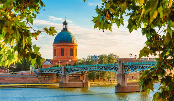 Photo of Toulouse, France. beautiful cityscape with The River Garonne and La Grave dome in the background at sunset.