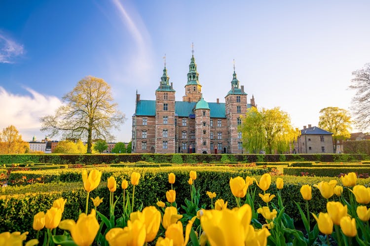 Photo of Rosenborg Castle Gardens in Copenhagen, Denmark with blue sky.