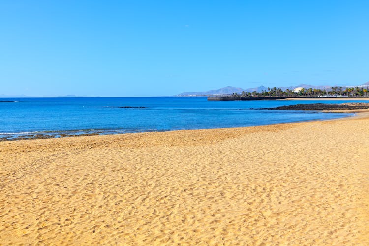 Photo of White beautiful sand beach located in Lanzarote, Playa Del Reducto Arrecife.