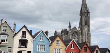 Photo of Colorful row houses with towering cathedral in background in the port town of Cobh, County Cork, Ireland.