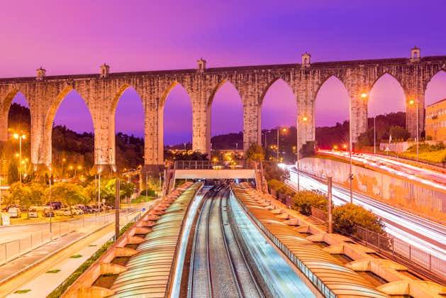 View of the historic aqueduct in the city of Lisbon (Aqueduto das Águas Livres), Portugal. Train station "Campolide" at the evening