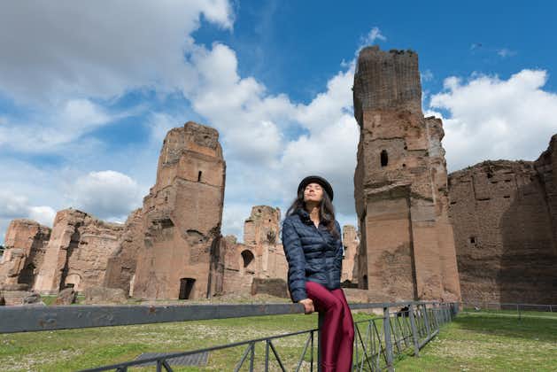 photo of Horizontal picture of woman posing in front of the ruins of Baths of Caracalla, important landmark located in Rome Italy .
