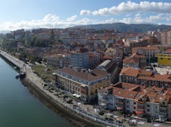 Photo of aerial view of Vizcaya bridge over the river and cityscape at Portugalete, Spain.