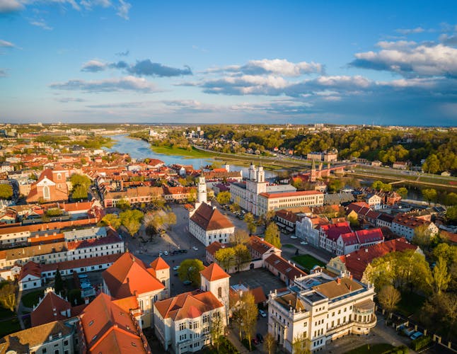 Photo of aerial view of a sunny day in Kaunas city town hall square with red roof tops.