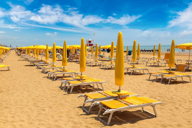Photo of umbrellas on the beach of Lido di Jesolo at adriatic Sea in a beautiful summer day, Italy.