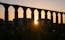 Santa Clara Aqueduct, Vila do Conde, Portugal at sunset with sun shining through arches and vivid orange sky