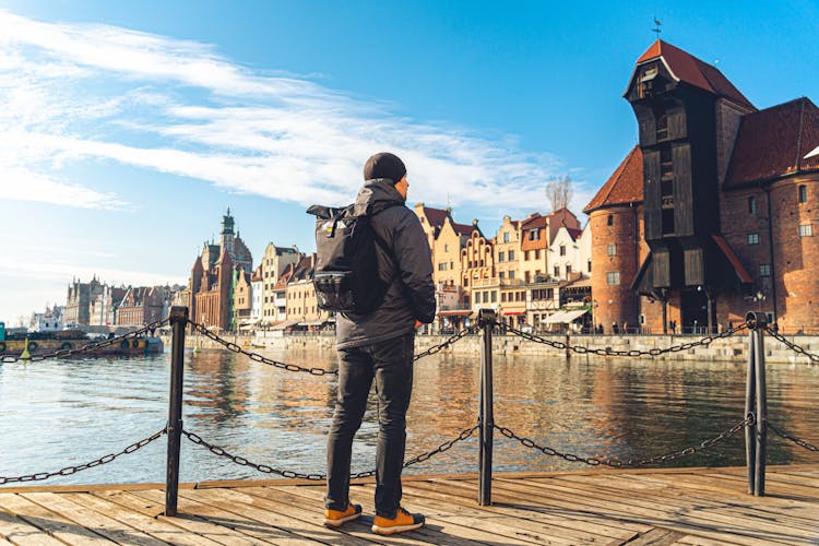 Photo of male tourist with a backpack in sunny winter in the old town of Gdansk.
