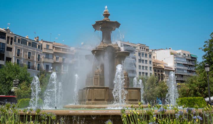 photo of the monumental fountain of battles during a sunny summer day in the city of Granada, Spain.