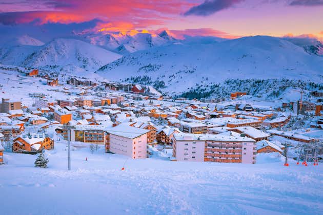 Photo of beautiful winter sport and travel destination. Well known winter ski resort and stunning ski slopes at colorful sunset, Alpe d Huez, France.