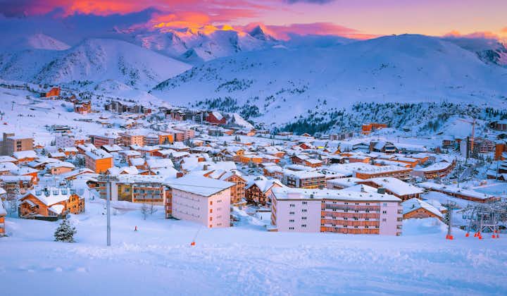 Photo of beautiful winter sport and travel destination. Well known winter ski resort and stunning ski slopes at colorful sunset, Alpe d Huez, France.