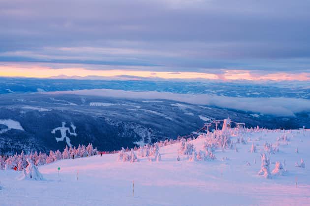 photo of an aerial view of ski resort Hafjell in Norway with skiers going down the snowy slopes in winter with mountains.