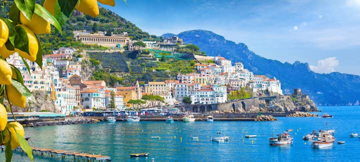 photo of panoramic view of beautiful amalfi on hills leading down to coast, Campania, Italy. Amalfi coast is most popular travel and holiday destination in Europe. Ripe yellow lemons in foreground.